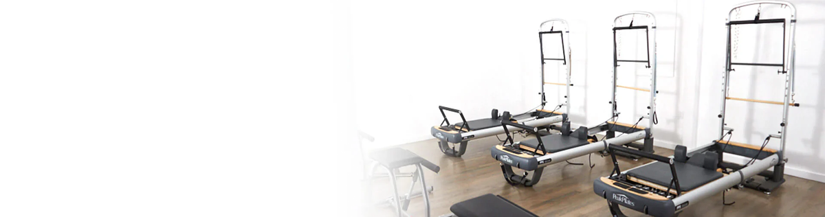 Gym equipment including reformers and ladders on a white background